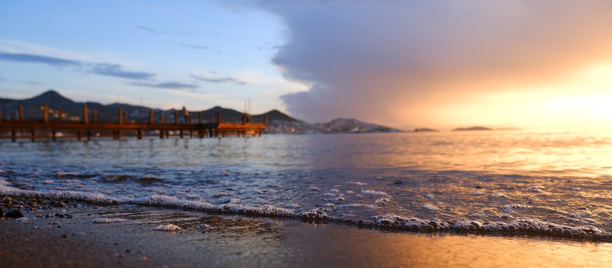 Golden hour beach with wooden pier, Bodrum, Turkey — rejected by Adobe Stock for quality